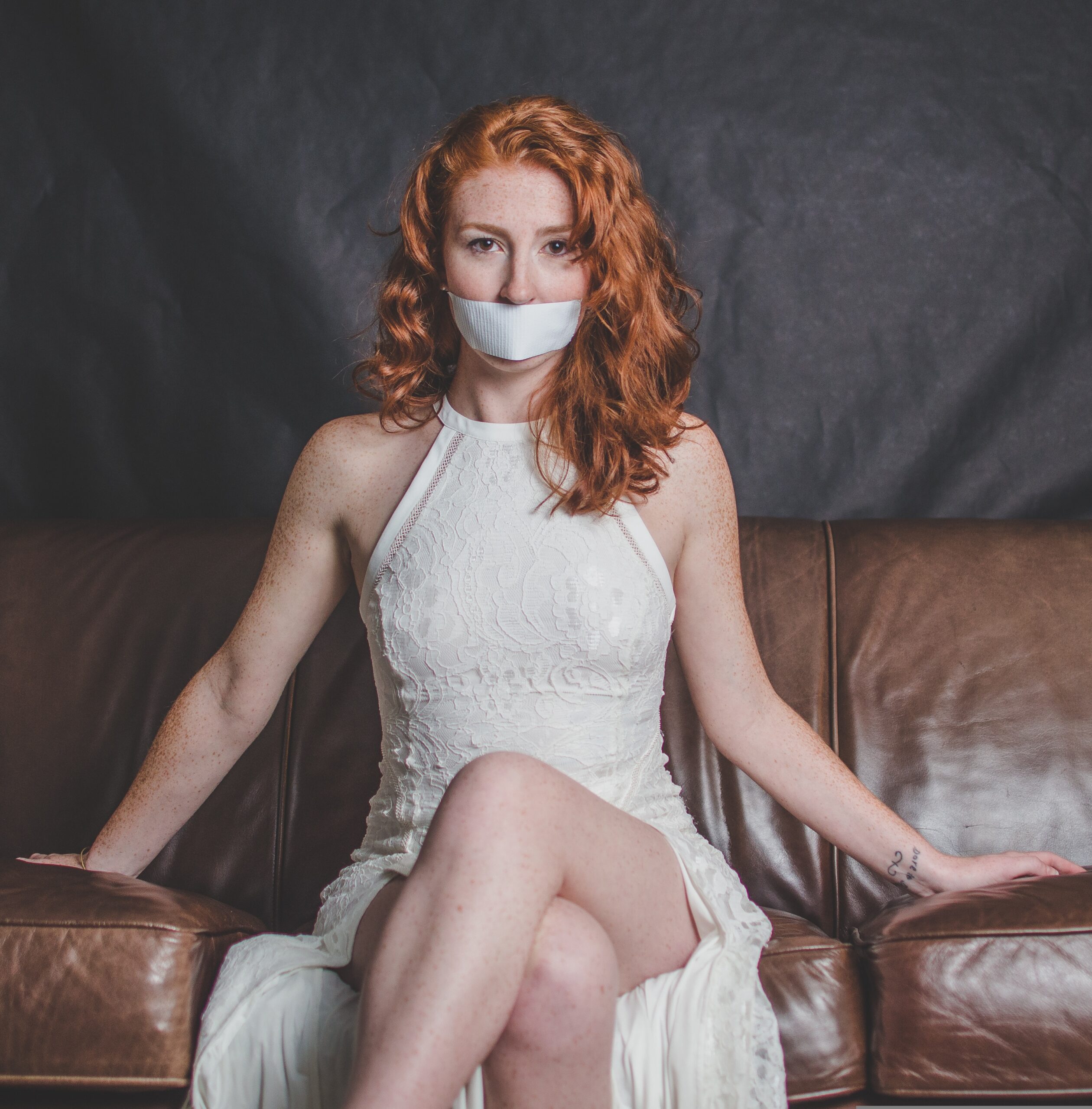 Woman with tape over her mouth symbolizing the struggle to express emotions and the importance of saying no and setting healthy boundaries for emotional wellness.