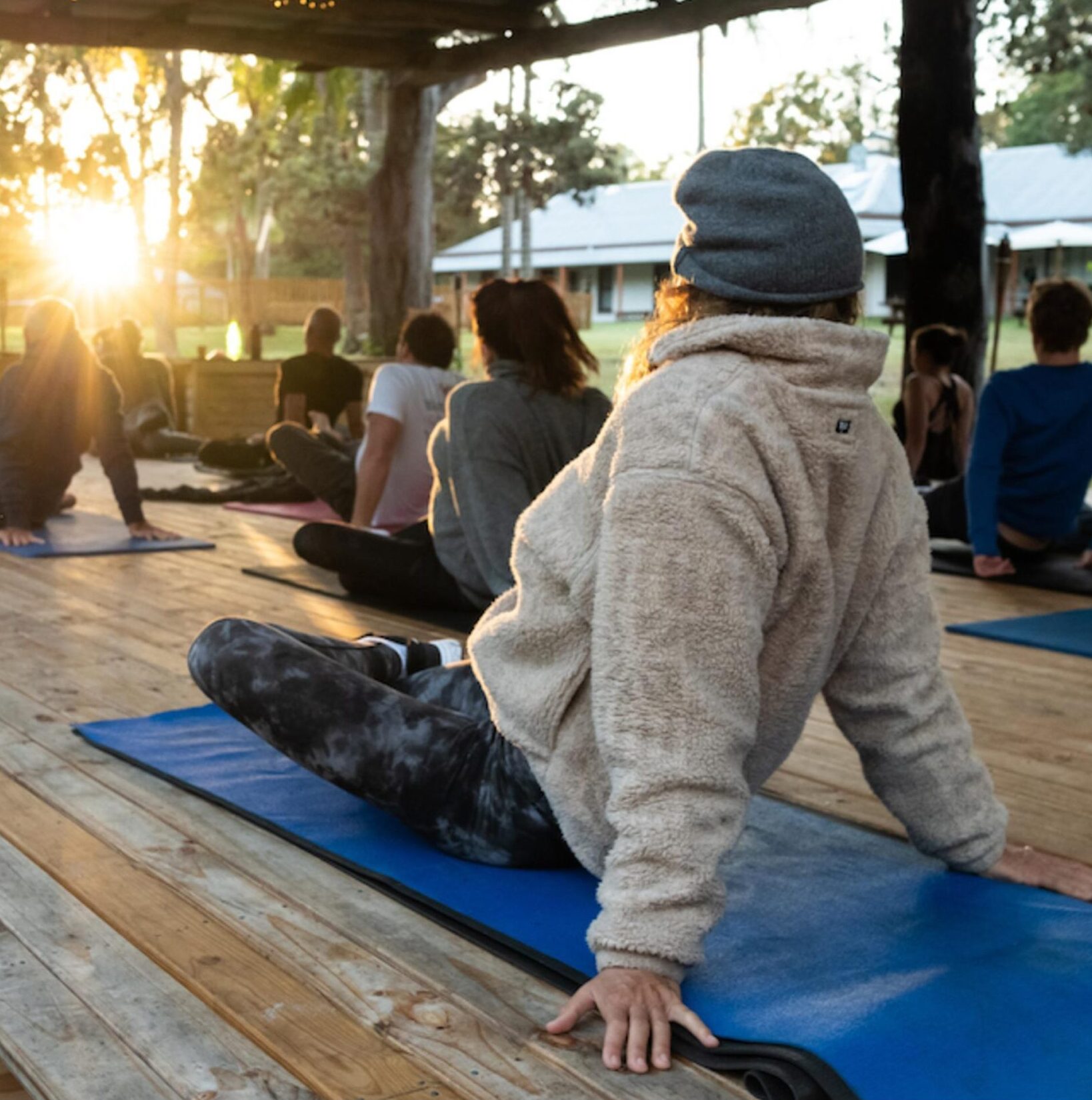 Group retreat session on an open wooden deck at sunrise — Healmee Signature Retreats
